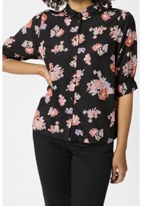 Czarna koszula z guzikami, ozdobiona kwiatowym wzorem w odcieniach różu, pomarańczy i niebieskiego. Krótkie rękawy, kołnierzyk oraz marszczenia na końcach rękawów.
