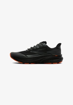 Schwarzer Laufschuh mit mesh-Obermaterial, orangen Akzenten, gepolstertem Kragen und dicker Sohle. Verfügt über ein Schnürsystem und eine strukturierte Außensohle für besseren Grip.