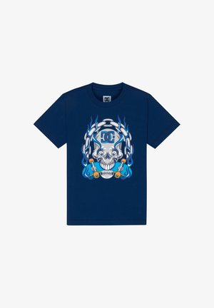 T-shirt en coton bleu marine avec un grand graphisme représentant un crâne entouré de flammes, de chaînes et d'éléments de skateboard aux couleurs vives.