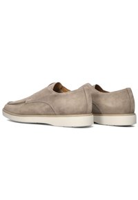 Beige suède instap schoenen met een naadloos ontwerp, voorzien van een platte crèmekleurige zool en een ronde neus. Accenten zijn gladde stikdetails.