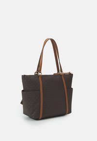 Sac fourre-tout à motifs marron avec deux anses en cuir, fermeture éclair et poches latérales. Présente des éléments en métal doré et un design structuré.