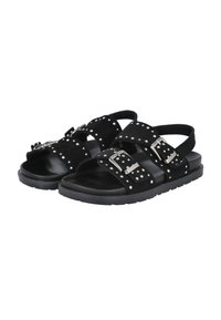 Sandalias de ante negro con dos correas anchas que presentan tachuelas de plata y hebillas ajustables. Planta negra lisa con un diseño antideslizante.