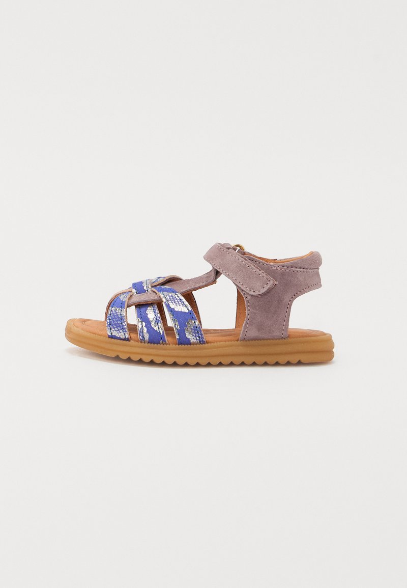 Lilla semsket sandal med blå og sølv mønstrede stropper, justerbar krok-og-løkke lukking, og en teksturert brun gummi såle.