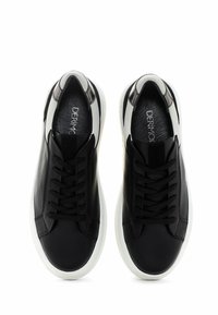 Zapatillas de cuero negro con paneles texturizados, suelas de goma blanca y cordones negros. Presentan un diseño elegante y minimalista con un acento oscuro en el talón.