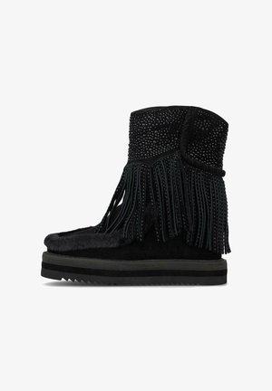 Bota de ante negro con un diseño de flecos, adornada con tachuelas, forro de piel de pelo y suela de goma texturizada.