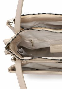 Beige læderhåndtaske med en glat tekstur og flere rum, med lynlåslukninger og foret indre. Lynlåslomme indvendigt.