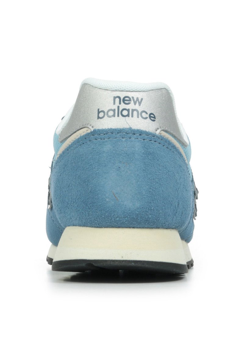 Sneakers en daim bleu et en mesh avec un contrefort argenté, comportant le logo "New Balance", des accents blancs et un col rembourré.