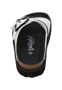 Black and white sandal with a cork insole, featuring a smooth synthetic upper and a large black buckle accent on the strap.