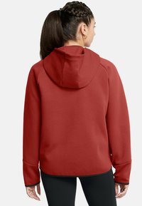 Felpa rossa con cappuccio in tessuto morbido, maniche raglan e orlo curvo. I polsini presentano un design senza cuciture per il massimo comfort.