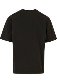 Camiseta de algodón negra con un corte clásico, mangas cortas y cuello redondo. Textura suave sin gráficos ni patrones visibles.
