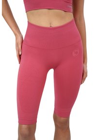 Pantaloni sportivi rosa realizzati in tessuto elasticizzato. Vita alta e design aderente con una texture liscia. Presenta un piccolo logo sulla gamba.