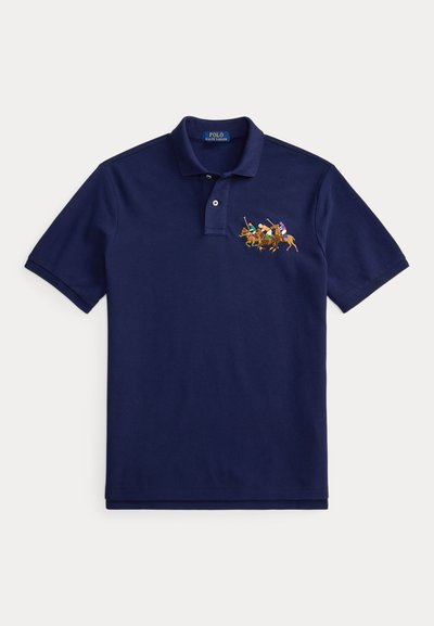 Polo majica mornarsko plave boje s ovratnikom i dva gumba, s izvezenim motivom četiri igrača poloa na konjima na prsima.