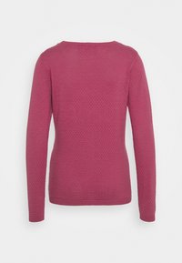 Pull ajusté à manches longues en tissu texturé couleur framboise, avec un col rond et des poignets côtelés ; dos lisse sans fermetures visibles.