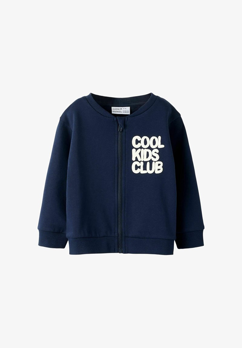 Tumed sinise värviga lastele mõeldud tõmblukuga sviiter, millel on pehme tekstuur ja kreemivärvi tekst "COOL KIDS CLUB". Ribitud varrukad ja helk.