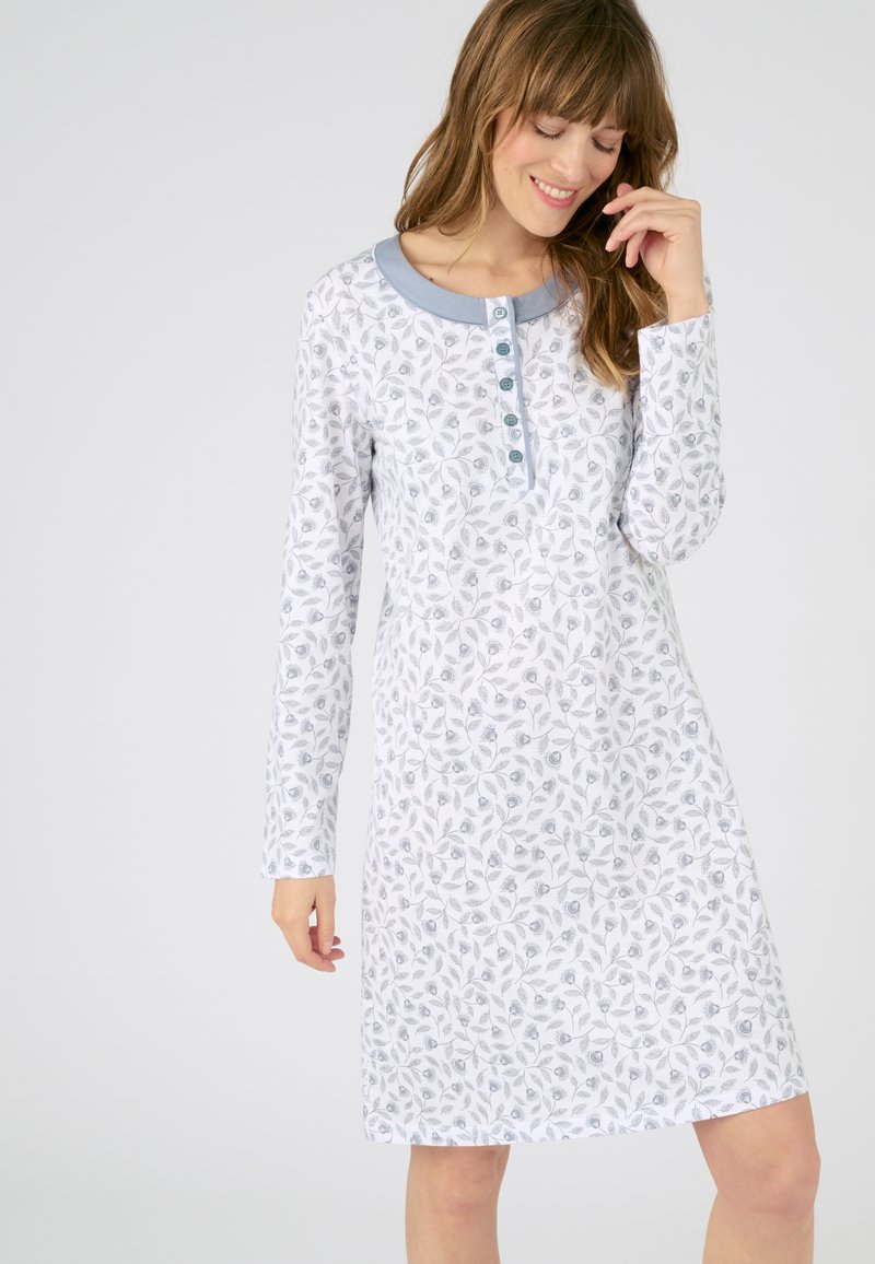 Camisón de manga larga en blanco con un patrón de hojas. Detalle de cuello azul claro y tapeta de botones. Tejido suave con un corte relajado.