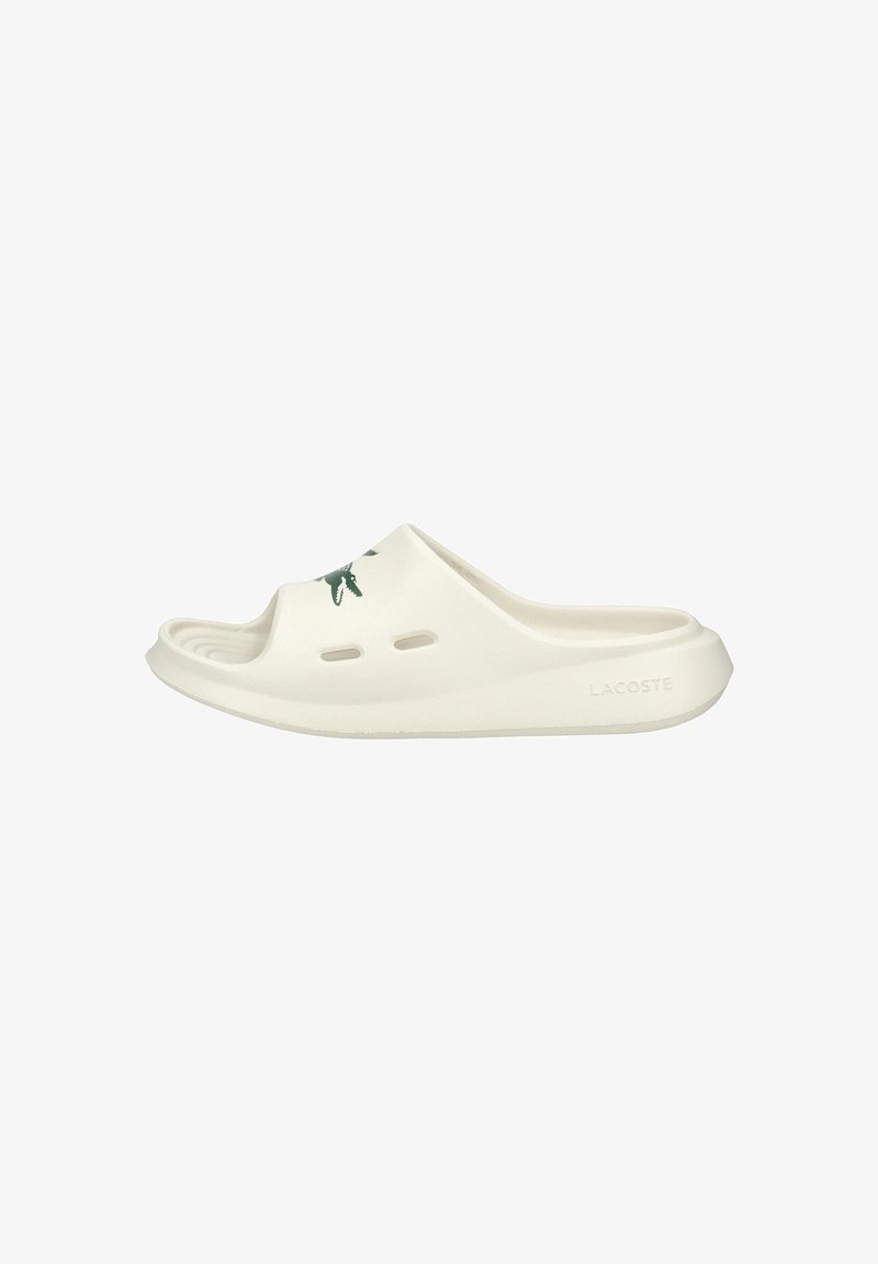 Λευκό σάνταλι Lacoste slide με ανοιχτά δάχτυλα, οπές αερισμού και πράσινο λογότυπο κροκόδειλου στο επάνω λουράκι.