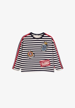 Camicia a maniche lunghe a righe blu navy e bianca con accenti rossi. Presenta toppe ricamate e un collo rotondo. Materiale in cotone morbido.