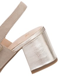 Beige suède sandaal met metallic blokhak en open achterkant, waarbij de zijkant en hiel details zichtbaar zijn tegen een witte achtergrond.
