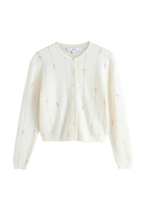 Cardigan blanc à manches longues, boutons sur le devant, fines lignes verticales grises, et petits motifs de nœuds roses dispersés sur le tissu.