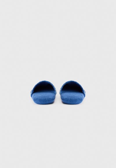 Μπλε παντόφλες από ύφασμα με ανοιχτή μύτη, μαλακή υφή και σχέδιο στο τελείωμα. Επίπεδη σόλα για εσωτερική χρήση.
