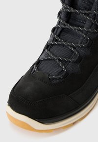 Czarne zamszowe buty sportowe z teksturowanym syntetycznym wierzchem, kontrastującymi sznurówkami oraz jasną gumową podeszwą. Posiadają wyściełany kołnierz.