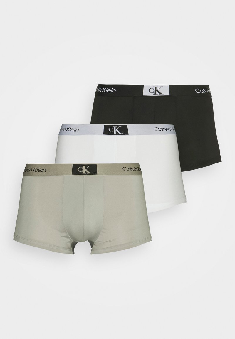 Tre paia di boxer da uomo: nero, bianco e grigio chiaro. Ognuno presenta un cinturino a contrasto con il logo "Calvin Klein" e una texture liscia.