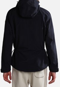 Chaqueta ligera de color azul marino con cintura ajustable con cordón, capucha y puños de Velcro. Textura suave, con detalles de costura minimalista.