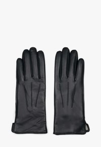 Een paar zwarte leren handschoenen met drie decoratieve stiknaden op de achterkant van elke hand, plat neergelegd op een witte achtergrond.