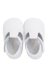 Scarpe per bambini in pelle bianca con design intagliato, punta rotonda e marchio in rilievo dorato all'interno. Texture liscia, suole morbide per il massimo comfort.
