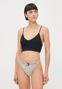Čierny rebrovaný bralet s tenkými ramienkami v kombinácii s šedým tangom s elastickým pásom s logom. Jednoduchý, minimalistický dizajn.