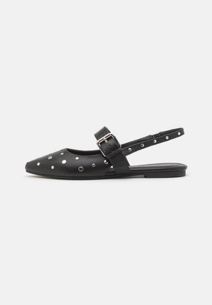 Czarny płaski but na pasku typu slingback z zaostrzonym noskiem, srebrnymi ćwiekami i regulowanym paskiem z klamrą.