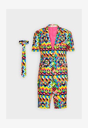 Farebný vzorovaný saká a zodpovedajúca kravata, ktoré sú zdobené geometrickými tvarmi v živých odtieňoch červenej, modrej, zelenej a žltej na čiernom pozadí.