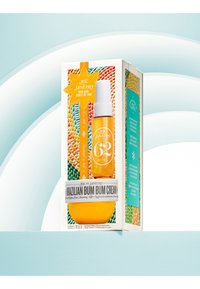 Scatola gialla con la crema Brazilian Bum Bum, bottiglia spray trasparente, sfondo testurizzato, con accenti di design a forma di perle multicolori.