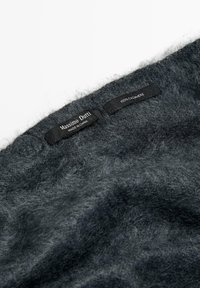 Dark gray cashmere fabric with a soft, fuzzy texture. Tags displaying "Massimo Dutti," "100% Cashmere," and "Made in China" are visible.