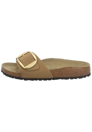 Sandale mule couleur camel avec semelle intérieure en liège, semelle extérieure noire à relief et grande boucle dorée réglable sur une large bride.