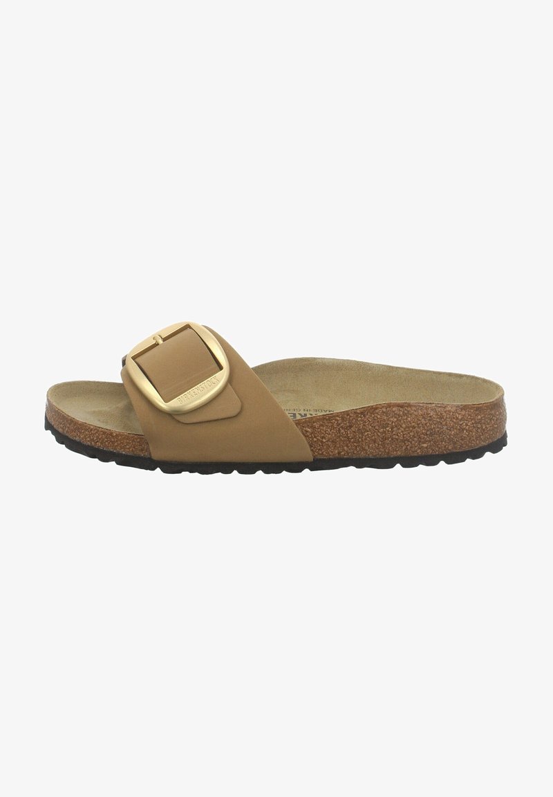 Sandale mule couleur camel avec semelle intérieure en liège, semelle extérieure noire à relief et grande boucle dorée réglable sur une large bride.