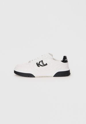 Witte leren sneaker met een zwarte rubberen zool, voorzien van een opvallend zwart logo en textuurdetails op de bovenkant.
