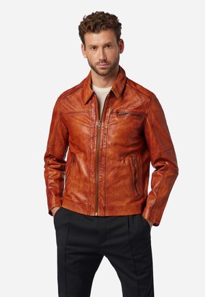 Veste en cuir d'un riche brun orangé avec fermeture éclair, col pointu et deux poches latérales. Présente un design à panneaux et un léger éclat.