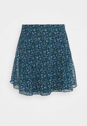 Jupe florale bleu foncé avec de petites fleurs blanches et bleues, tissu fluide et ourlet légèrement évasé.