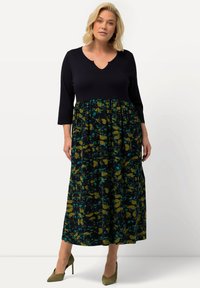 Robe maxi avec un haut bleu marine, décolleté en V et manches 3/4 ; motif floral en vert et teal sur la partie jupe ; tissu doux, design fluide.