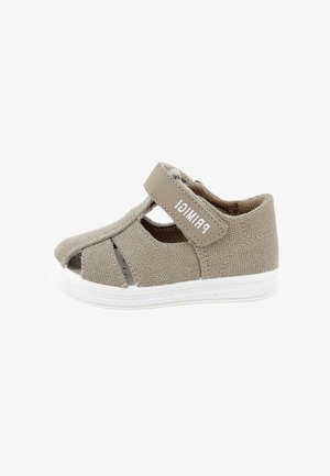 Sandalo beige per bambino piccolo con tomaia in tessuto, design con ritagli, cinturino in velcro con etichetta "PRIMIGI" e suola in gomma bianca.
