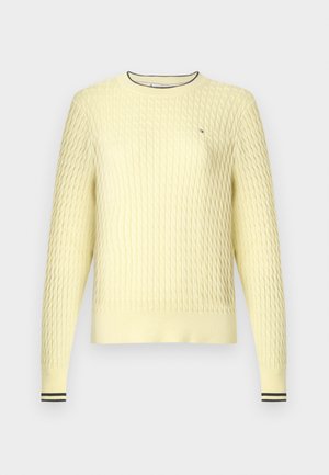 Rumeno pleten pulover z teksturiranim vzorcem, rebrastimi manšetami in izrezom z črnimi črtami. Na prsih ima majhen logotip.