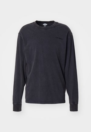 Chemise à manches longues en charbon foncé, fabriquée en coton doux. Présente un col rond et un logo brodé sur la poitrine. Coupe classique.