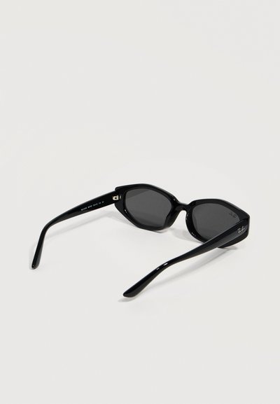 Черни слънчеви очила тип котешко око с тъмни лещи, лого Ray-Ban на рамото, показани отзад на бял фон.