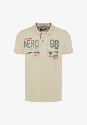 Polo beige con colletto, bottoni e testo stampato che include "AERO", "98" e "AIRCRAFT/SPACECRAFT" sulla parte anteriore.