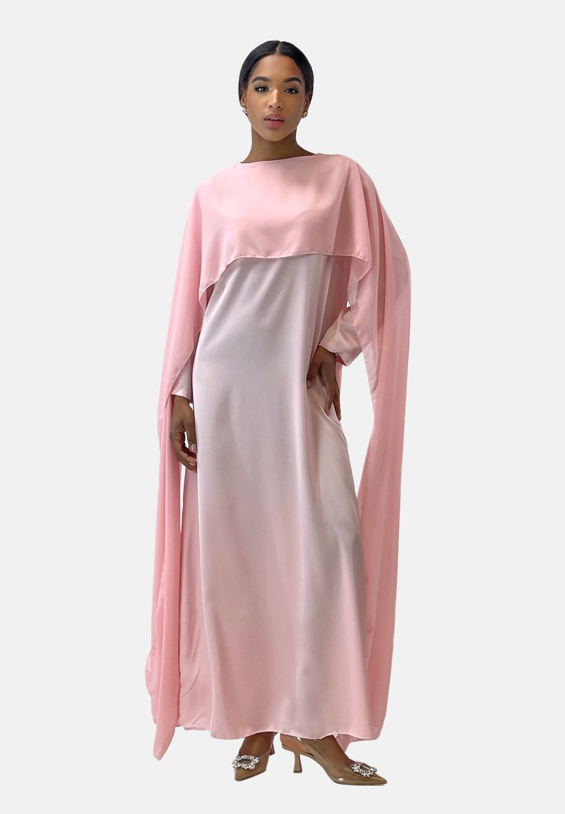 Robe en satin rose avec un design de cape fluide, manches longues et texture lisse. Elle présente un col haut et une silhouette élégante.