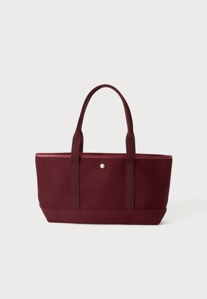 Bolso tote rectangular grande color burdeos con dos asas a juego y un pequeño botón redondo dorado en la parte frontal.
