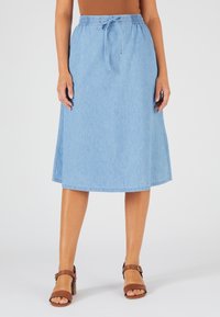 Jupe en denim bleu clair avec une taille élastique, un cordon de serrage et des fentes latérales près de l'ourlet. Texture lisse. Portez-la avec des sandales marron.