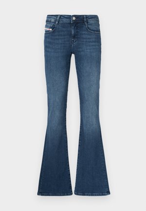 Tamsiai mėlyni platėjantys džinsai su aptemptu liemeniu, penkių kišenių dizainu, šiek tiek išeidžiančiu blukinimu ant šlaunų ir metaliniu mygtuku liemens užsegimui.