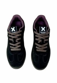 Sneaker in suede nero con design a scarpa bassa, lacci marroni e fodera interna viola. Il cartellino del logo presenta una 'X' bianca su sfondo nero.